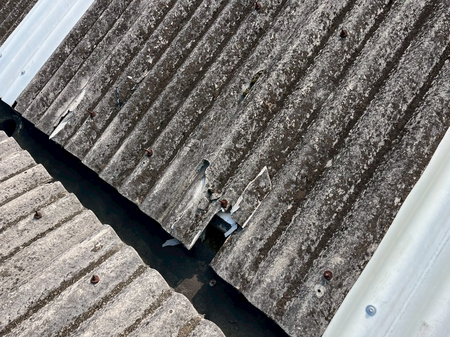 ひび割れと欠けが発生している波型スレート屋根